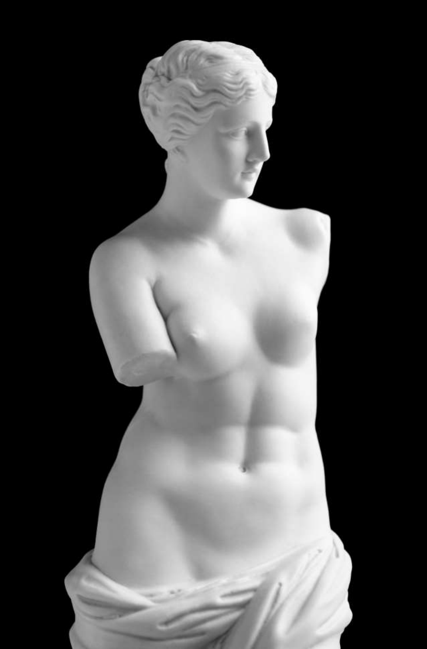 Fotografía de la estatua de la Venus de Milo (Afrodita de Melos, siglo II a.C., Museo del Louvre), reproducida en blanco sobre fondo negro. Muestra el torso desnudo de la figura femenina con los brazos ausentes y un paño que cubre la parte inferior del cuerpo.